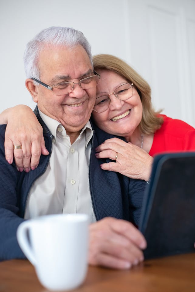 Happy senior couple smiling while making a video call at home, connected and joyful.