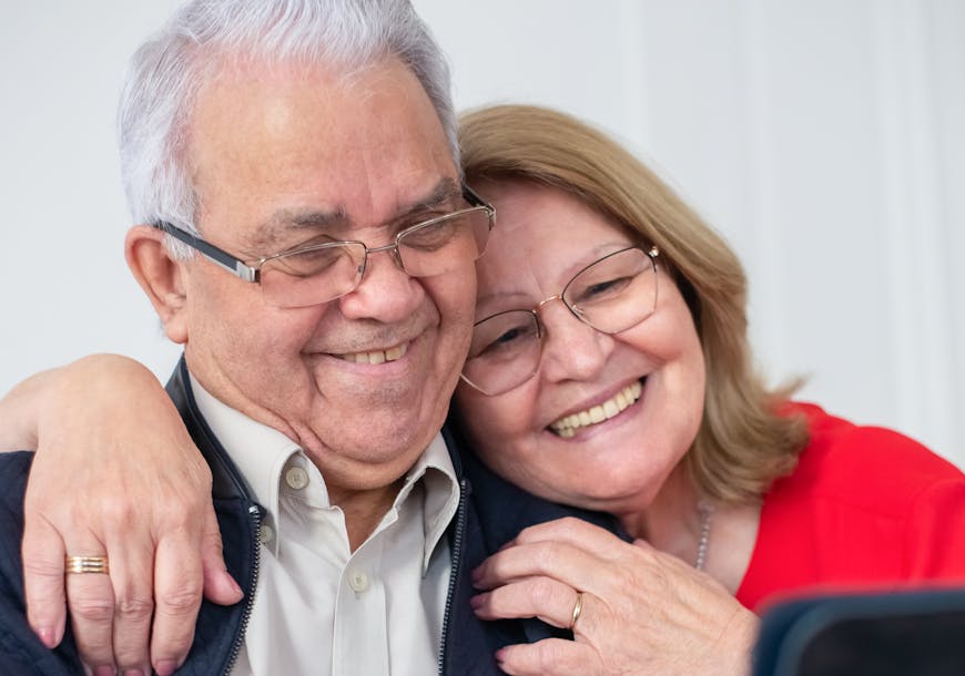 Happy senior couple smiling while making a video call at home, connected and joyful.