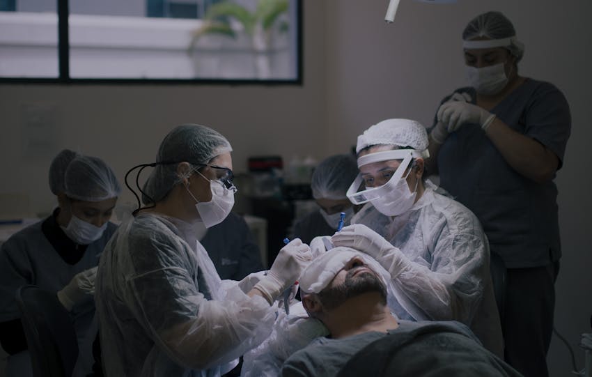 Surgeons conduct a hair transplant procedure in a modern operating room.